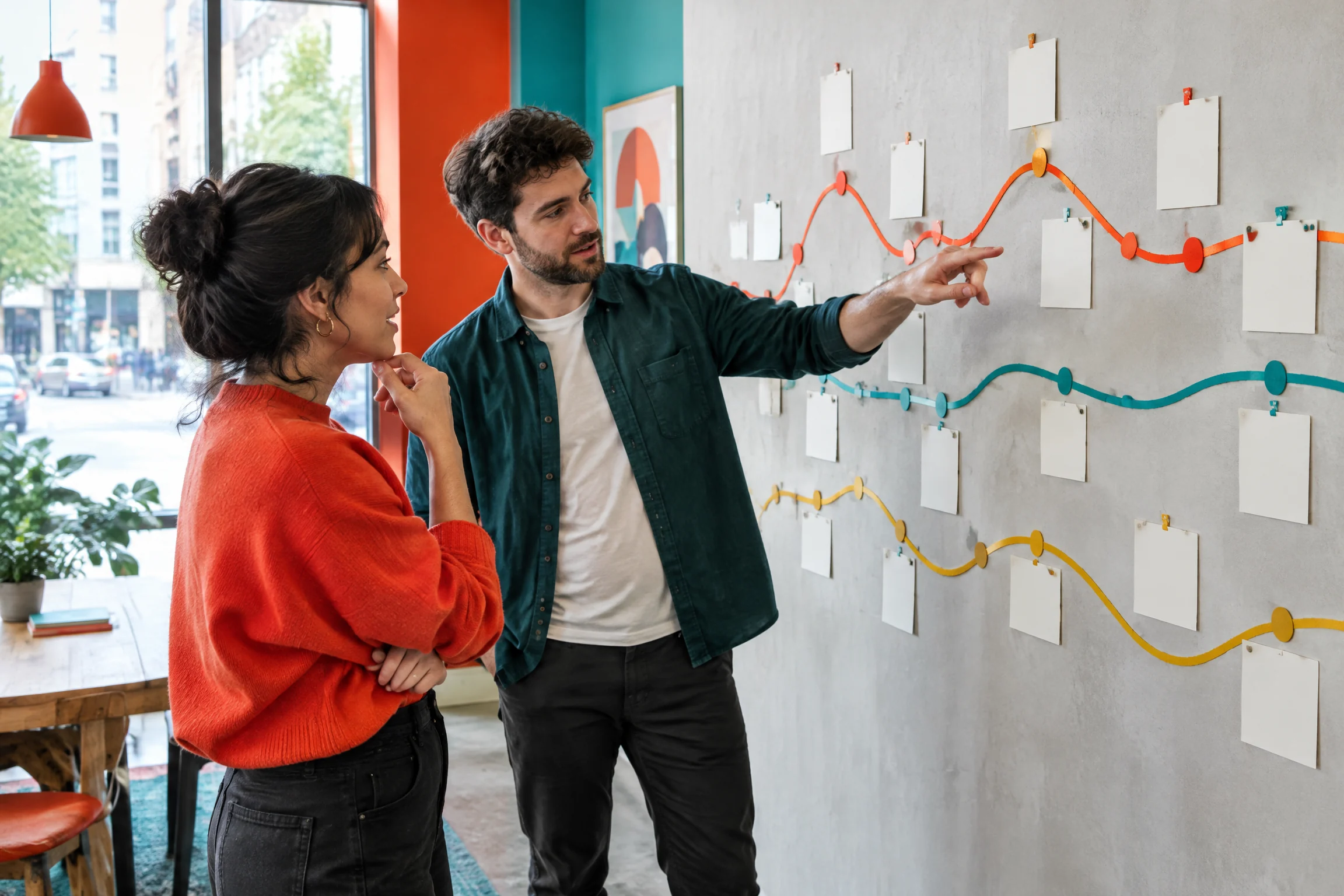 Two product professionals reviewing a physical customer journey wall